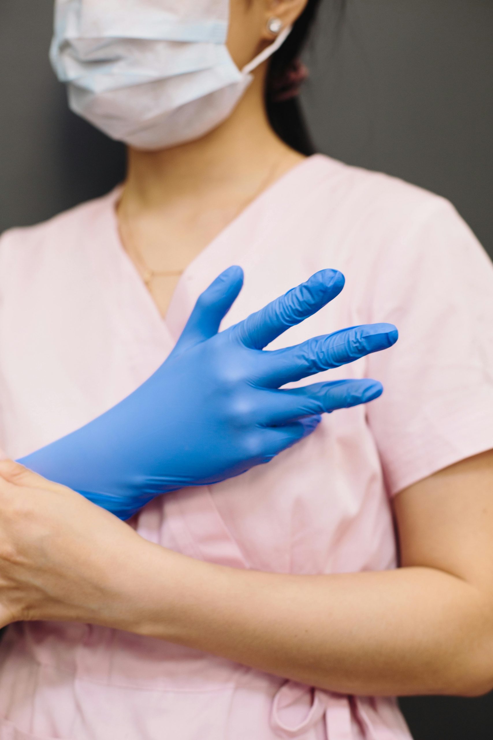 Medical professional wearing a face mask and gloves, representing pandemic safety practices.